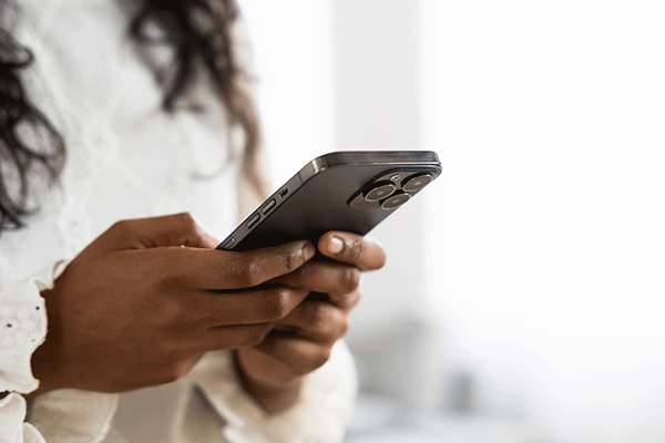 – DETAIL OF AN AFRICAN AMERICAN FEMALE HOLDING A DIGITAL PHONE. 